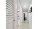 Hallway featuring tile floors, white trim, and multiple doors leading to various rooms in the home at 15014 Winterwind Dr, Tampa, FL 33624