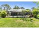 Private backyard featuring a screened pool enclosure, lush landscaping, and a well-kept lawn at 16214 W Course Dr, Tampa, FL 33624