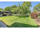 Expansive backyard featuring a screened lanai, a well-manicured lawn, and secure black fencing at 16214 W Course Dr, Tampa, FL 33624