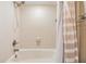 Clean bathroom featuring a shower and tub with a tiled surround, and shower curtain at 16214 W Course Dr, Tampa, FL 33624