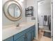 Bathroom features a blue vanity and a round mirror at 16214 W Course Dr, Tampa, FL 33624