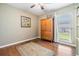 Cozy bedroom with hardwood floors, a large window, and a spacious armoire at 16214 W Course Dr, Tampa, FL 33624