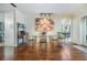 Dining room showcasing a glass table, metal chairs, wood floors, and modern art at 16214 W Course Dr, Tampa, FL 33624