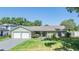 Charming single-story home featuring an attached two-car garage and well-maintained landscaping at 16214 W Course Dr, Tampa, FL 33624
