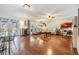 Open-concept living room features wood floors, large sectional couch, and sliding glass doors at 16214 W Course Dr, Tampa, FL 33624