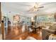Open-concept living room features wood floors, large sectional couch, and sliding glass doors at 16214 W Course Dr, Tampa, FL 33624