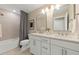 Bright bathroom with a double vanity, sleek mirrors, and a shower-tub combination for a clean, modern look at 16411 Sapphire Point Dr, Lakewood Ranch, FL 34211