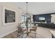 Elegant dining area with a glass table, seating for four, modern lighting, and access to the living area at 16411 Sapphire Point Dr, Lakewood Ranch, FL 34211