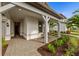 Covered entry with gray posts, chair, and green plants on each side at 16411 Sapphire Point Dr, Lakewood Ranch, FL 34211