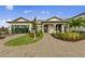 Charming single-story home featuring a brick driveway, manicured lawn, and covered entryway at 16411 Sapphire Point Dr, Lakewood Ranch, FL 34211