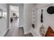 Hallway with built-in shelving and bench, hat hook, and view into dining and kitchen area at 16411 Sapphire Point Dr, Lakewood Ranch, FL 34211