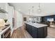 Open kitchen featuring a large island with a sink, quartz countertops, and views into the open living area at 16411 Sapphire Point Dr, Lakewood Ranch, FL 34211
