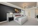 Elegant bedroom featuring a stylish accent wall, decorative lighting, and a glimpse into the en-suite bathroom at 16411 Sapphire Point Dr, Lakewood Ranch, FL 34211