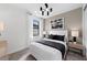 Serene bedroom featuring a white bed with black accents, modern lighting, and a view from the window at 16415 Sapphire Point Dr, Lakewood Ranch, FL 34211