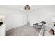 Bright Bedroom featuring gray carpet, a modern light fixture, and a rocking chair next to a white crib at 16415 Sapphire Point Dr, Lakewood Ranch, FL 34211