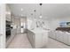 Modern kitchen with a large island and stainless steel appliances opening up to the living room at 16415 Sapphire Point Dr, Lakewood Ranch, FL 34211