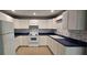 Well-equipped kitchen with white cabinets, modern appliances, blue countertops and tiled backsplash at 1708 E Genesee St, Tampa, FL 33610