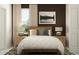 Cozy bedroom with neutral bedding, wood accents, bedside tables, and a mountain view wall art at 17504 Nectar Flume Dr, Land O Lakes, FL 34638