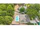 Aerial view showcasing a home with a pool and spa, nestled within a lush, green neighborhood at 18520 Ambly Ln, Tampa, FL 33647