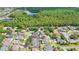 Wide aerial view of a residential area with houses, pools, and lush trees near a lake at 18520 Ambly Ln, Tampa, FL 33647