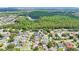 Expansive aerial view of a neighborhood with houses, green trees, and a lake in the distance at 18520 Ambly Ln, Tampa, FL 33647