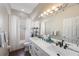 Bright bathroom features a double sink vanity, a shower with tub, and lots of natural light at 18520 Ambly Ln, Tampa, FL 33647