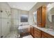 Well-lit bathroom features a double sink vanity, glass shower, and a large soaking tub at 18520 Ambly Ln, Tampa, FL 33647