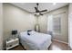 Well-lit bedroom featuring wood floors, ceiling fan, and a large window with curtains at 18520 Ambly Ln, Tampa, FL 33647