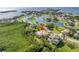 Aerial view of a charming home with a pool, surrounded by lush landscaping and a scenic lake at 2101 N Pointe Alexis Dr, Tarpon Springs, FL 34689