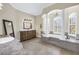 Luxurious bathroom with a soaking tub, tiled accents, and a vanity with marble countertop at 2101 N Pointe Alexis Dr, Tarpon Springs, FL 34689
