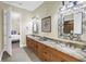 Spacious bathroom with double sinks, granite countertops, and decorative mirrors at 2101 N Pointe Alexis Dr, Tarpon Springs, FL 34689