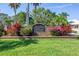 A charming community entrance with lush greenery and colorful flowers welcomes residents and visitors to Harbour Watch at 2101 N Pointe Alexis Dr, Tarpon Springs, FL 34689