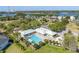 Aerial view showcases a community pool, playground, and tennis court surrounded by lush landscaping and beautiful waterfront views at 2101 N Pointe Alexis Dr, Tarpon Springs, FL 34689