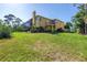 Expansive lawn surrounds a two-story home featuring a screened enclosure, balcony, and lush landscaping at 2101 N Pointe Alexis Dr, Tarpon Springs, FL 34689