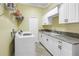 Well-equipped laundry room with modern appliances, ample counter space, and storage cabinets at 2101 N Pointe Alexis Dr, Tarpon Springs, FL 34689