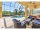 Inviting screened-in pool area featuring a refreshing pool, lush landscaping, and comfortable seating at 2101 N Pointe Alexis Dr, Tarpon Springs, FL 34689