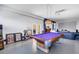 Spacious recreation room with a pool table, projector screen, and comfortable seating area for entertainment at 2101 N Pointe Alexis Dr, Tarpon Springs, FL 34689