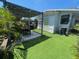Lush backyard features verdant turf, a covered patio, and mature palms at 212 41St S St, St Petersburg, FL 33711