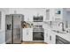 Modern kitchen with stainless steel appliances, white cabinets, white countertops, and marble backsplash at 2211 Belleair Rd # D3, Clearwater, FL 33764