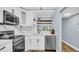 Bright kitchen featuring stainless steel appliances, marble backsplash, and view through the pass-through to the dining area at 2211 Belleair Rd # D3, Clearwater, FL 33764