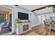 Spacious living room showcasing wood-look flooring, a console table, television, and sliding glass door to the outside at 2211 Belleair Rd # D3, Clearwater, FL 33764