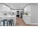 Modern white kitchen featuring stainless steel appliances and breakfast bar with seating at 2214 Selkirk St, Valrico, FL 33594
