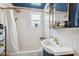 Bathroom with white tiled walls, black-and-white tiled floors, white bathtub and a unique pedestal sink at 2217 Stuart St, Tampa, FL 33605