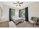 Cozy bedroom featuring natural light through two windows with charming blue curtains and a decorative ceiling fan at 2217 Stuart St, Tampa, FL 33605