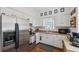 Eat-in Kitchen featuring white cabinets, stainless steel refrigerator and oven, and stainless steel sink with a window at 2217 Stuart St, Tampa, FL 33605