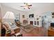 Cozy living room featuring a decorative fireplace, ceiling fan and rich hardwood floors at 2217 Stuart St, Tampa, FL 33605