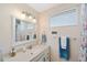 Bathroom features a walk-in shower, single sink vanity, window, mirror, light fixtures, and linen closet at 2417 Sunset Vista Dr, Spring Hill, FL 34607