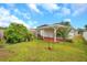 View of the backyard with a covered patio, lush green grass, and surrounding fence at 2907 Mingo Dr, Land O Lakes, FL 34639