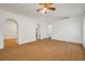 Open-concept living room with hardwood floors, ceiling fan, and arched doorways at 2907 Mingo Dr, Land O Lakes, FL 34639