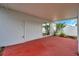 Covered patio with red concrete flooring, access to the backyard and sliding glass door at 2907 Mingo Dr, Land O Lakes, FL 34639